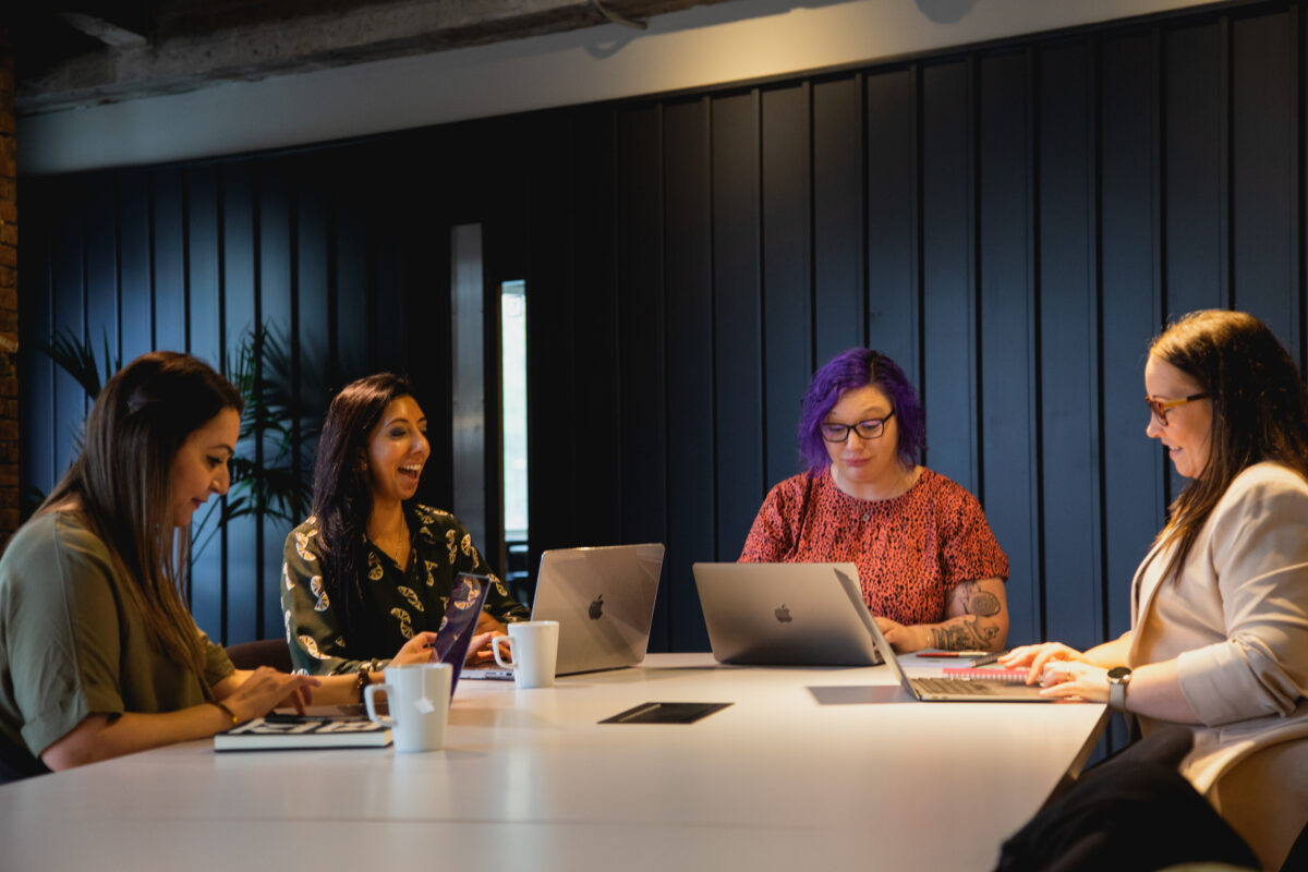 A group of women sitting around an office table working