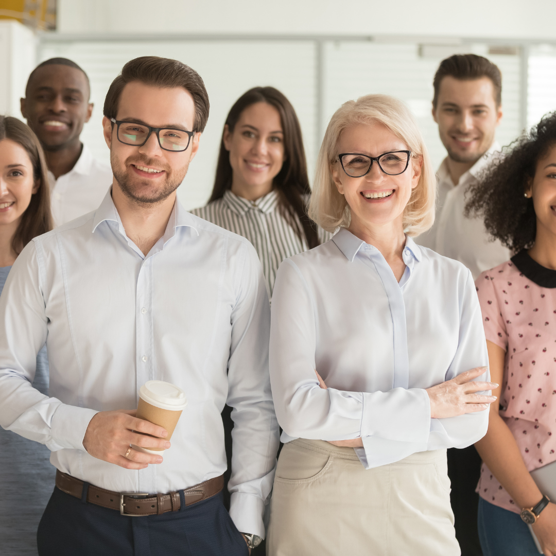 A group of people smiling in an office space