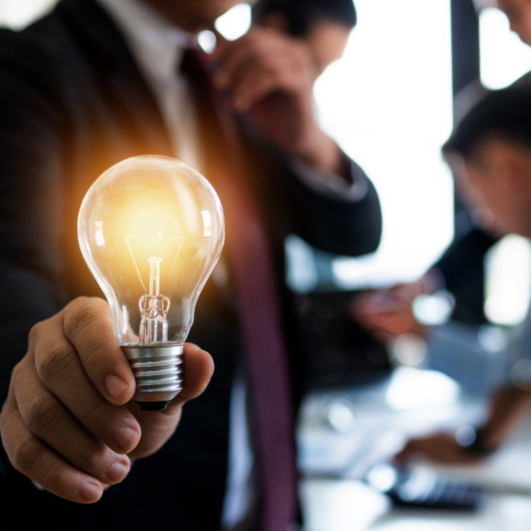 A man holding a lit lightbulb