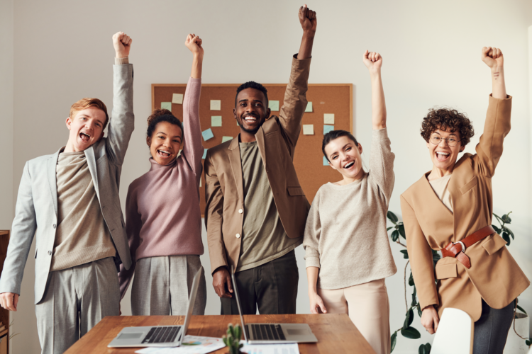 A group of people in an office fisting the air