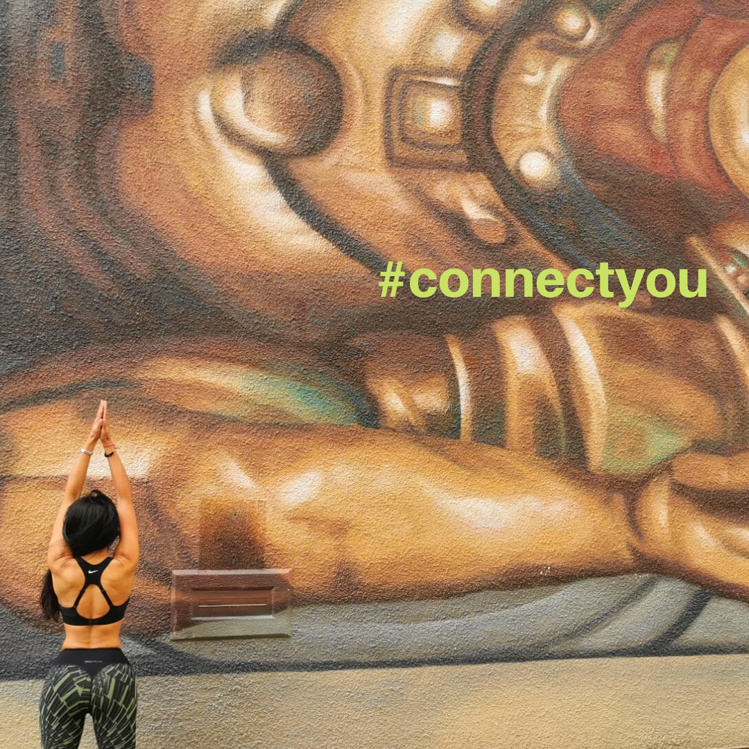 Leena Parmar doing yoga in front of a mural