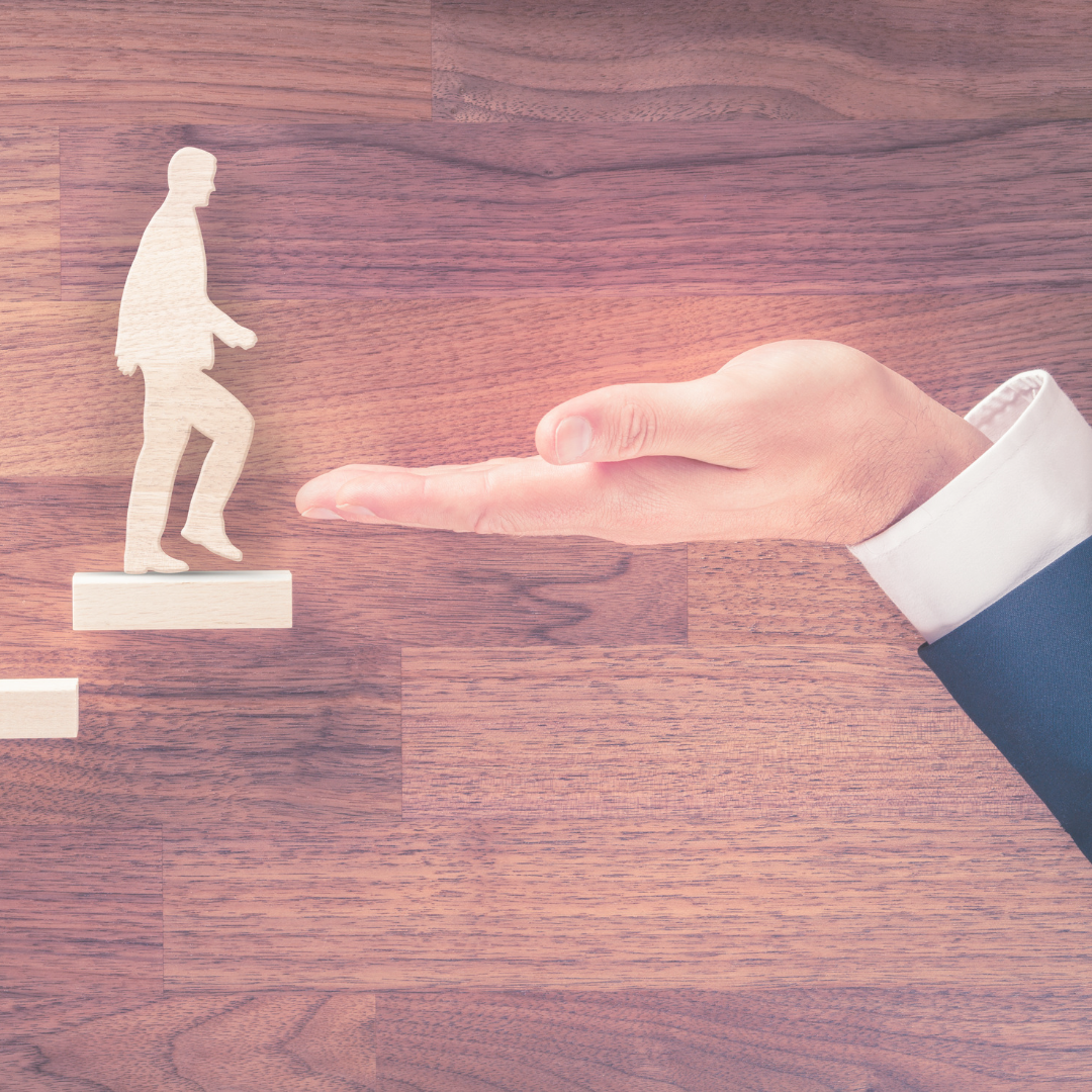 A paper figure human walking up blocks to a human hand.