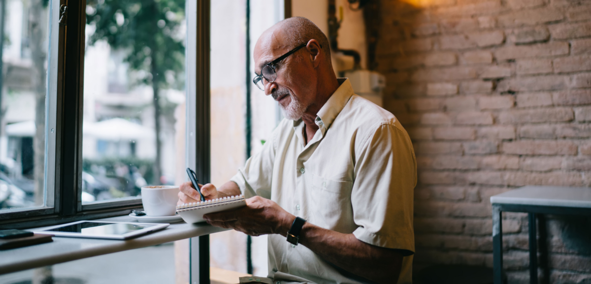 A man making notes in a coffee shop
