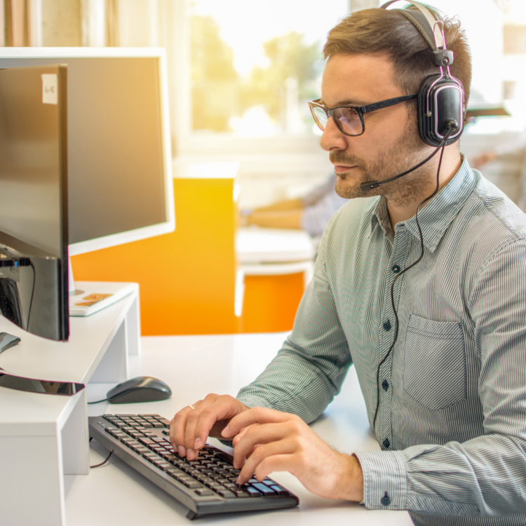 A man with a headset working at a desk