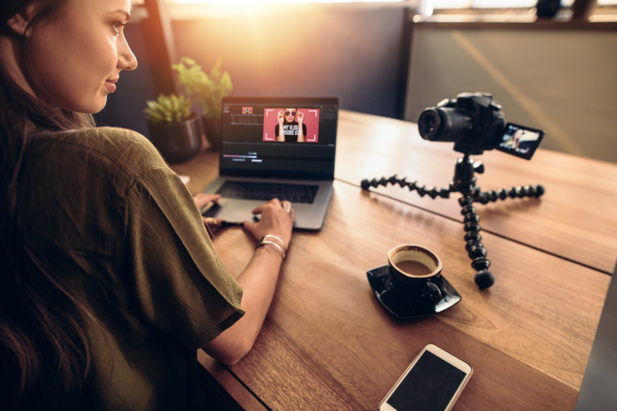 A woman editing a video while looking into a camera
