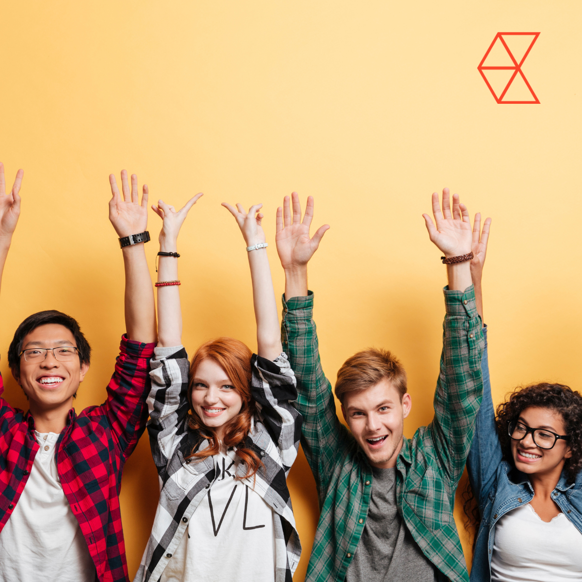 A group of people with their hands in the air smiling
