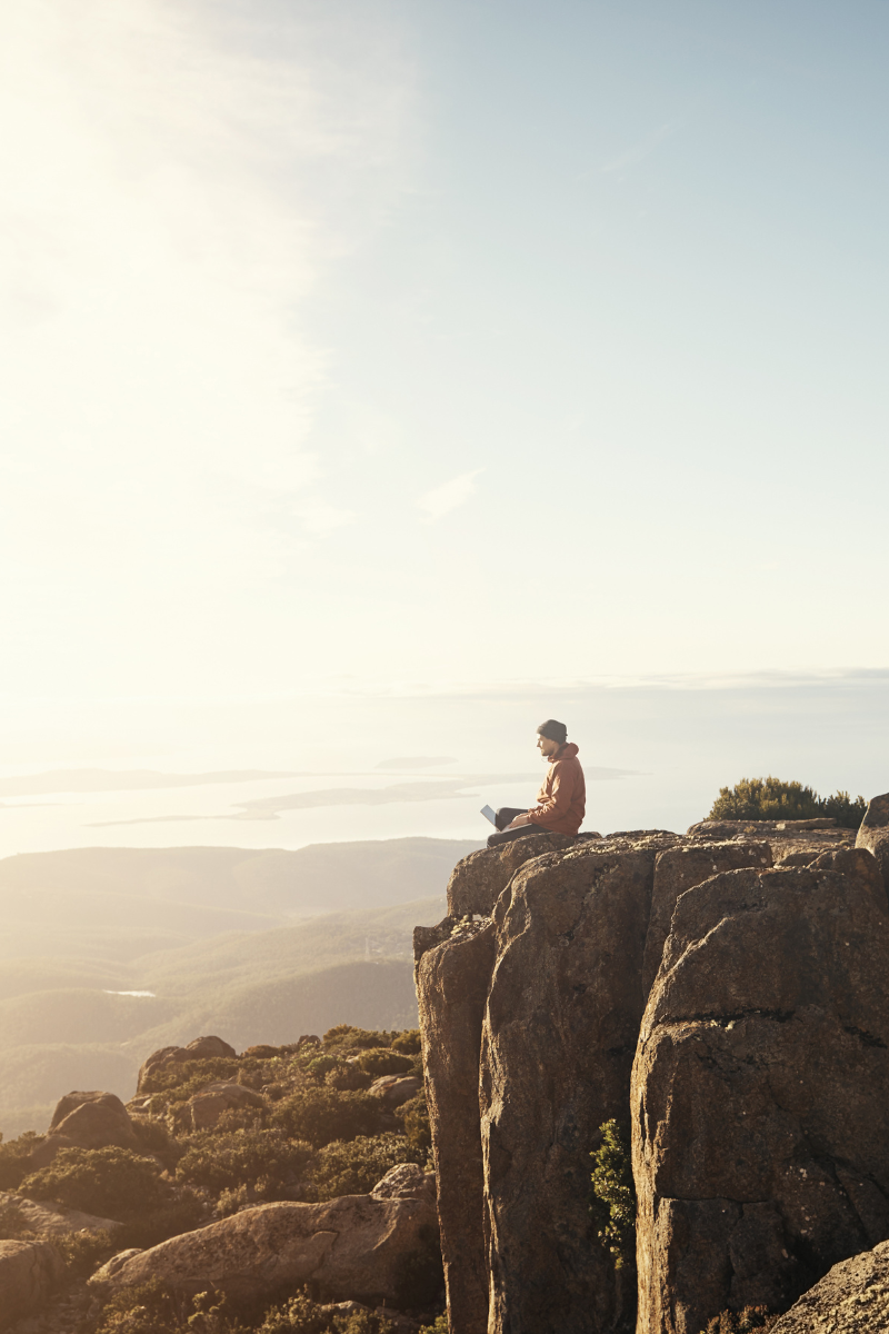 A man sitting on a cliffs edge.