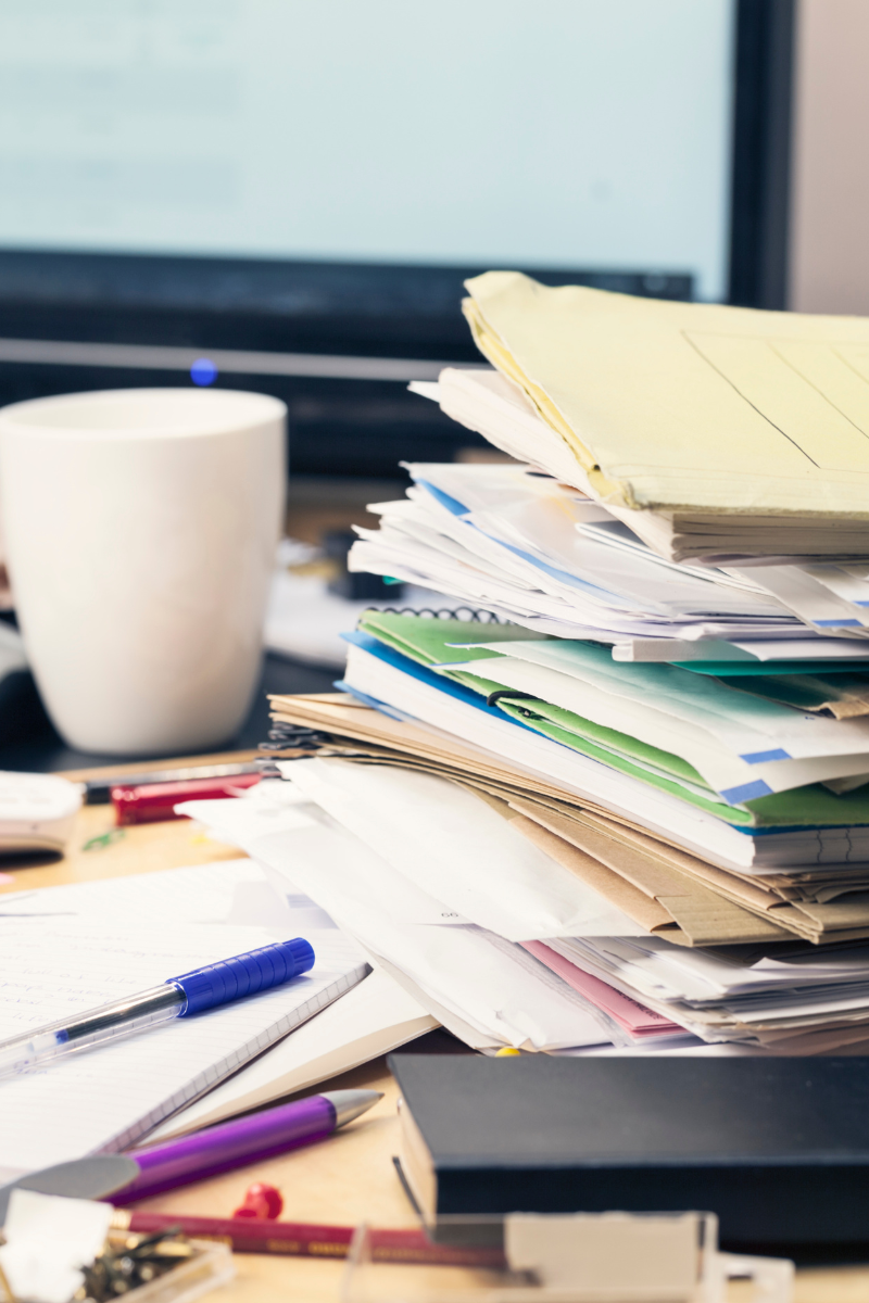 A stack on papers on a messy desk